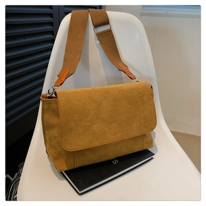 Macro detail of mustard yellow suede tote bag featuring brown canvas wide shoulder strap