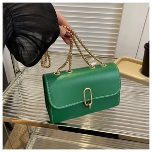 Detail of green leather handbag with white contrast stitching and gold oval lock