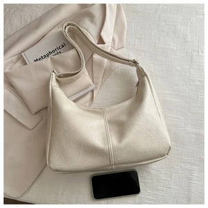 Detailed texture of off-white crescent tote bag with soft PU leather and metal zipper