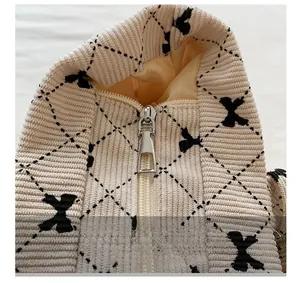 Macro shot of corduroy fabric texture with embroidered bows and metal zipper detail