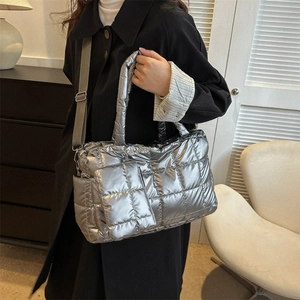Silver quilted metallic puffer crossbody bag with matching accessory pouch on grey strap
