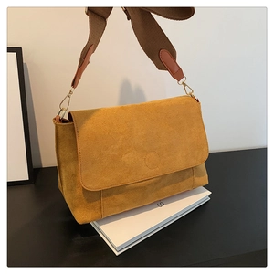 Detail view of ginger matte texture shoulder bag with brown strap and gold metal buckle