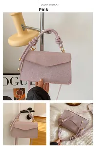 Detail of pink glitter handbag featuring a unique knotted top handle and flap closure