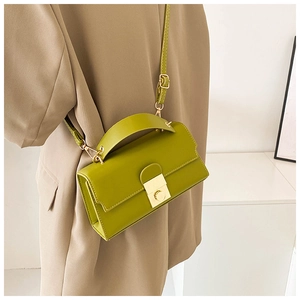 Avocado green leather mini bag with gold hardware worn over a khaki blazer