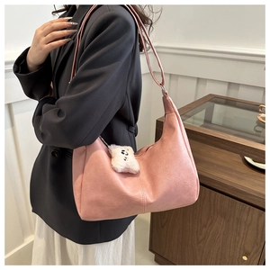 Detail view of pink PU hobo bag featuring a white plush bear charm and stitch accents