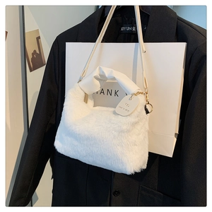 Detail of white faux fur tote with pleated leather handle and gold hardware buckle