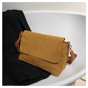 Detail of ginger matte crossbody bag with a wide canvas strap and flip-top closure