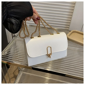 Detailed macro view of white leather bag featuring a gold U-shaped twist lock and chain strap