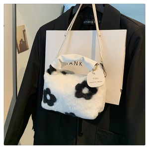 Close-up of black and white floral plush hobo bag with PU handle and designer tag