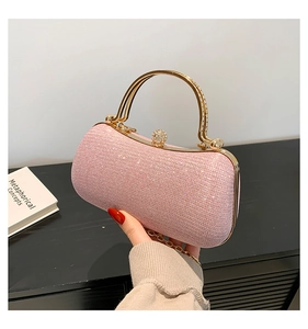 Détail de la pochette de soirée rose pailletée avec poignée dorée et fermoir en cristal