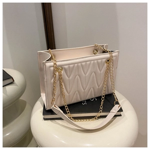 Detail of cream white PU shoulder bag with wavy quilted texture and gold chain strap