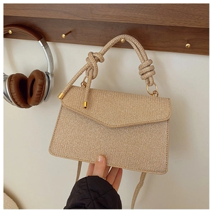 Detail of glitter woven flap handbag with thick knot handle and long shoulder strap