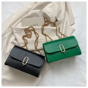 Detail view of stylish crossbody bags in black and green with gold metal clasps
