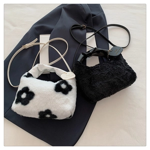 Detail of plush faux fur shoulder bags with flower pattern and ruffled handles
