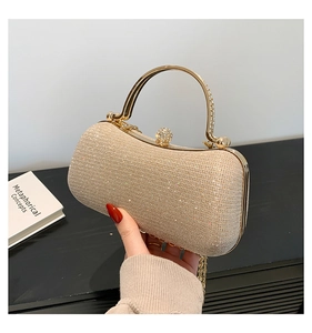 Détail de la pochette de soirée pailletée or champagne avec poignée métallique