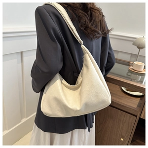 Detail of the soft cream faux leather texture and elegant Hobo silhouette on shoulder bag