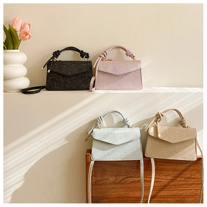 Close-up of stylish glitter crossbody bags in black, pink, blue, and champagne gold colors