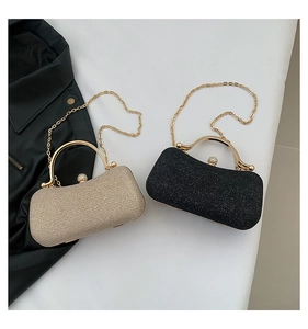 Détails du fini pailleté et de la poignée dorée de cette pochette de soirée chic