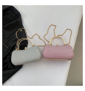 Détail de pochettes de soirée pailletées argent et rose avec poignées dorées et bandoulières