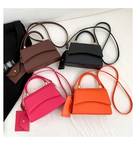 Detail view of crocodile pattern crossbody bags with woven handles in various colors