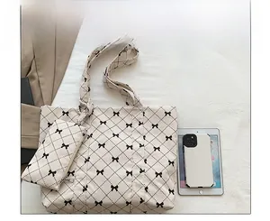 Corduroy tote bag set with bow pattern and matching pouch shown next to a tablet for scale
