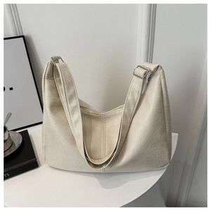 Detail view of cream shoulder bag featuring natural crinkle texture and wide strap