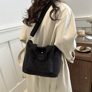 Minimalist black nylon tote bag for women shown on model for daily commuting style