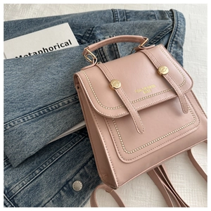 Detailansicht des rosa Lederrucksacks mit goldenen Nieten und rundem Metalldrehschloss