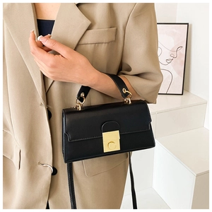 Chic black structured handbag featuring a gold square twist lock and smooth leather texture