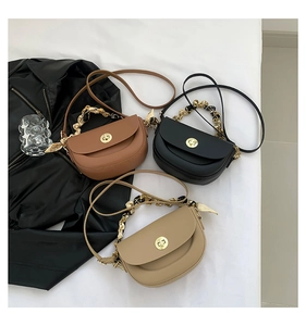 Detailed view of three saddle bags with silk scarf wrapped chain handles in neutral tones