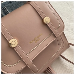 Detailansicht der rosa PU-Leder Tasche mit goldenen Metallschnallen und Radialnähten
