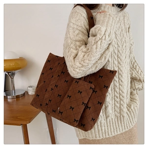 Close-up of corduroy tote bag with bow patterns and matching small pouch
