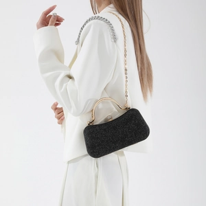 Sac de soirée noir pailleté avec poignée en métal doré et chaîne sur blazer blanc chic