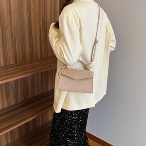 Elegant champagne glitter crossbody bag with knot handle and envelope flap closure