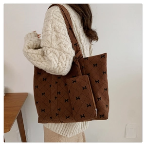 Close-up of brown corduroy tote set with quilted diamond texture and bow embroidery