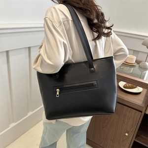 Retro black leather tote bag with functional back zipper pocket shown on shoulder