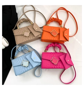 Detail of crocodile pattern bags in four colors with pleated handles and mini pouches