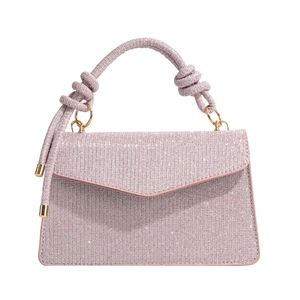 Pink glitter trapezoid handbag with twisted top handle and gold hardware in minimalist style