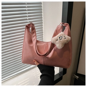 Detail of pink PU leather tote with vertical stitching and star plush pendant