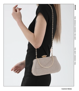 Close-up of champagne gold sequin evening clutch bag with metal chain and jewel clasp