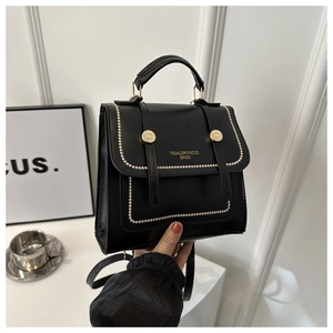Detail of black PU leather briefcase with gold rivets and metallic handle accents