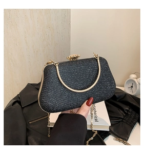 Close-up of black sequin evening bag featuring gold floral clasp and metal chain strap