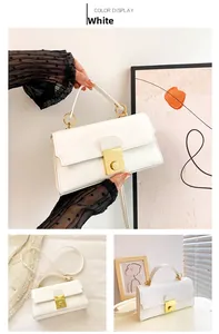 Detail of white rectangle handbag featuring golden metal twist lock and round handle links