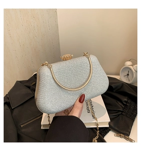 Close-up of silver glitter evening bag with gold handle and floral clasp detail