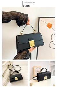 Detail of minimalist black handbag showing gold metal lock and circular handle link