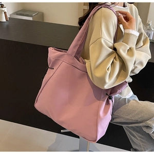 Detail of purple nylon tote bag with drawstring side showing waterproof fabric texture