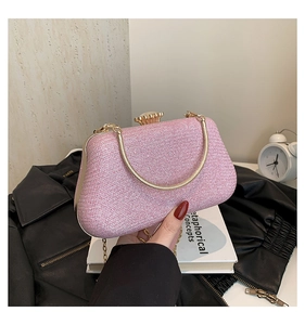 Detail of pink sequin clutch featuring gold metal handle and sparkling evening finish