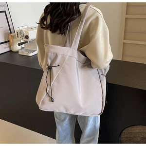 Détail du sac cabas en nylon imperméable avec texture froncée et longue bandoulière de sac