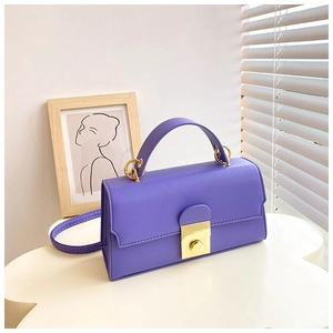 Macro detail of violet leather handbag featuring golden metal clasp and ring hardware