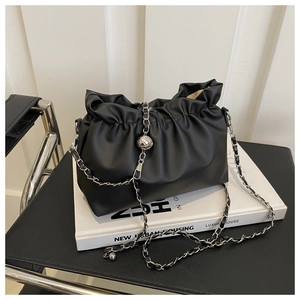 Close-up of black pleated bucket bag with silver metal ball and chain shoulder strap